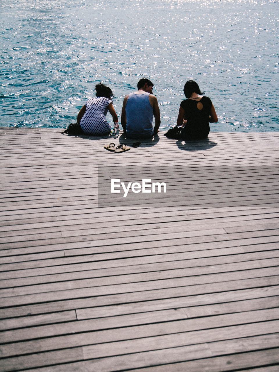 HIGH ANGLE VIEW OF PEOPLE SITTING ON SHORE