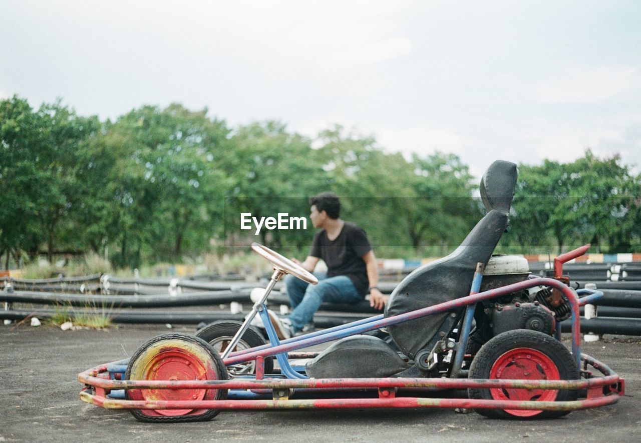 Sports car against man sitting at running track