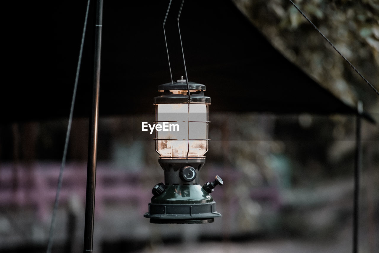 CLOSE-UP OF ELECTRIC LAMP HANGING FROM METAL