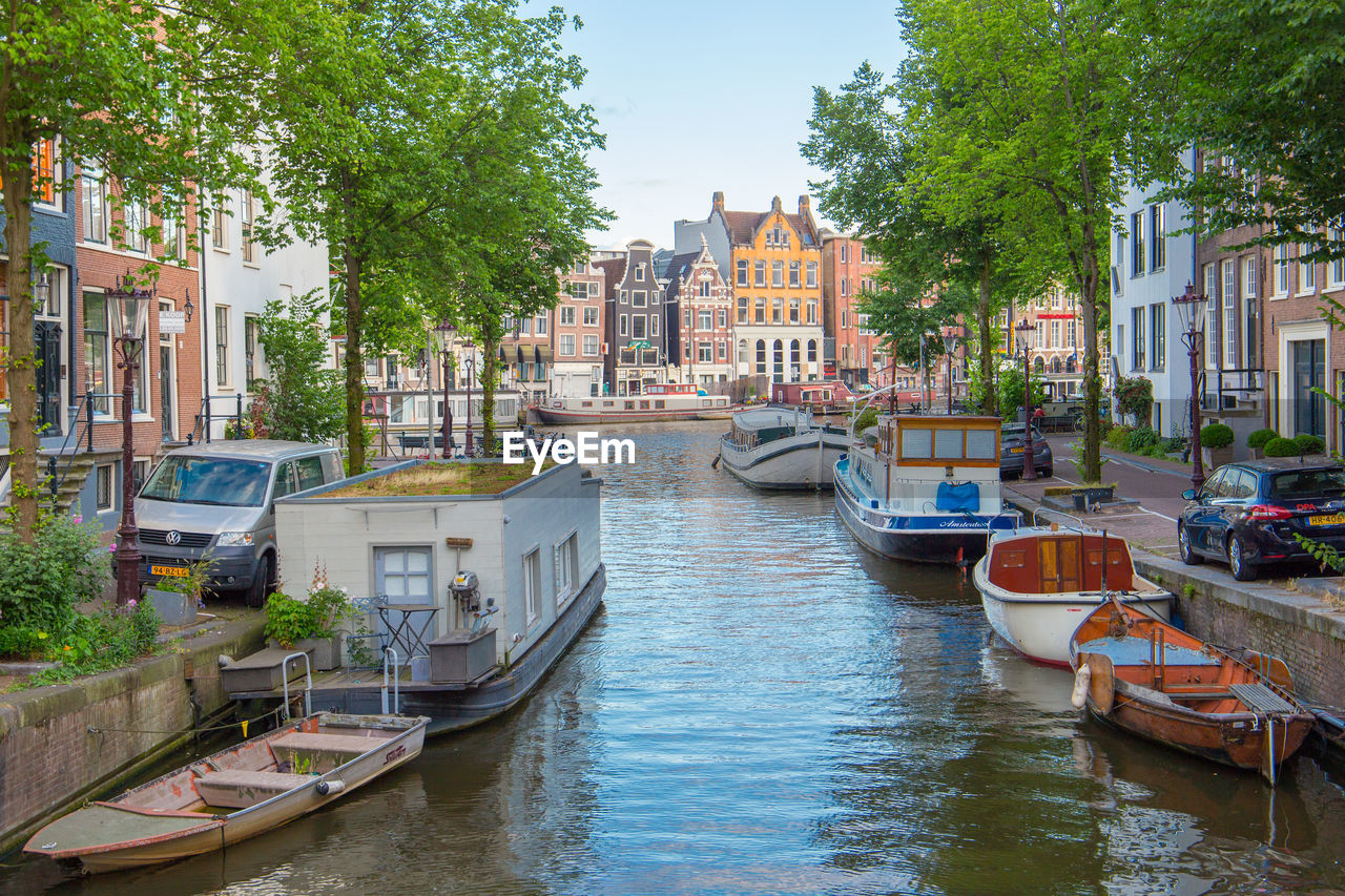 Boats moored on canal in city