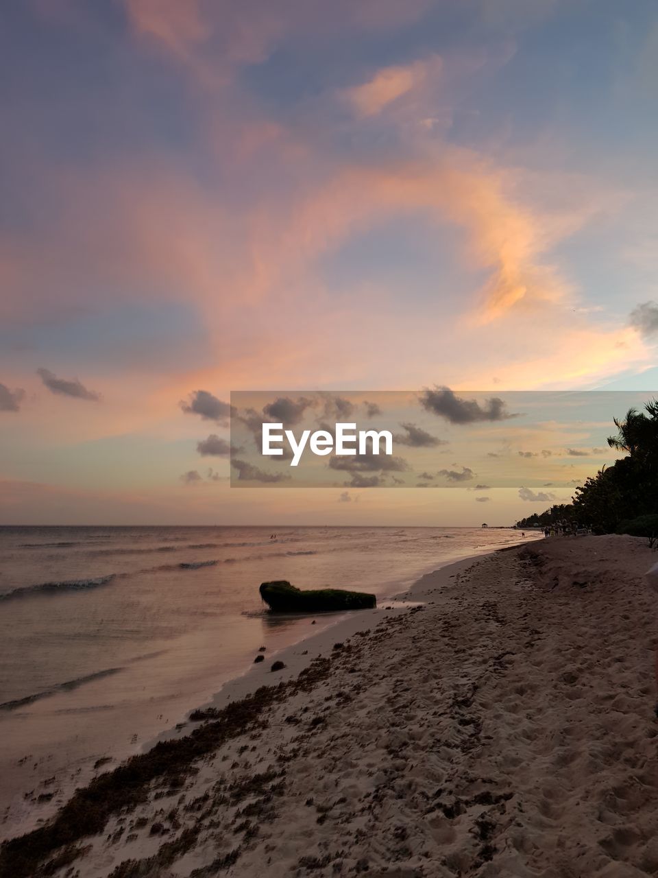 SCENIC VIEW OF BEACH AGAINST SKY AT SUNSET