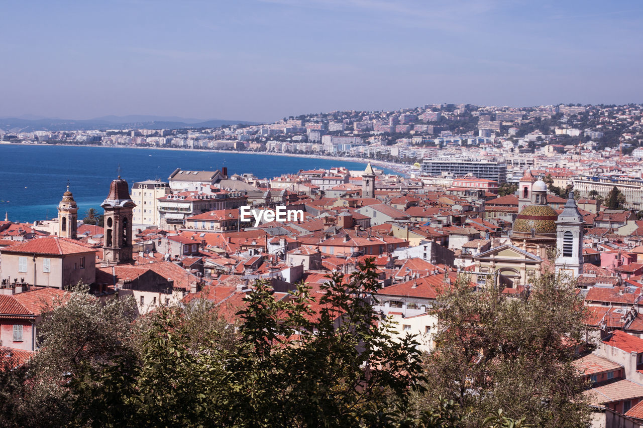 HIGH ANGLE VIEW OF TOWNSCAPE AGAINST SEA