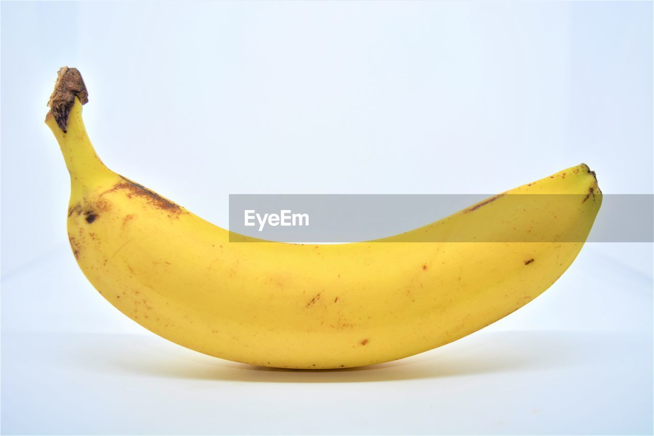 CLOSE-UP OF BANANA AGAINST WHITE BACKGROUND