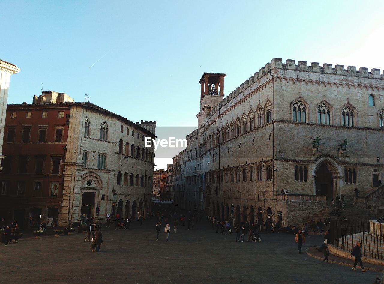 GROUP OF PEOPLE IN FRONT OF BUILDINGS