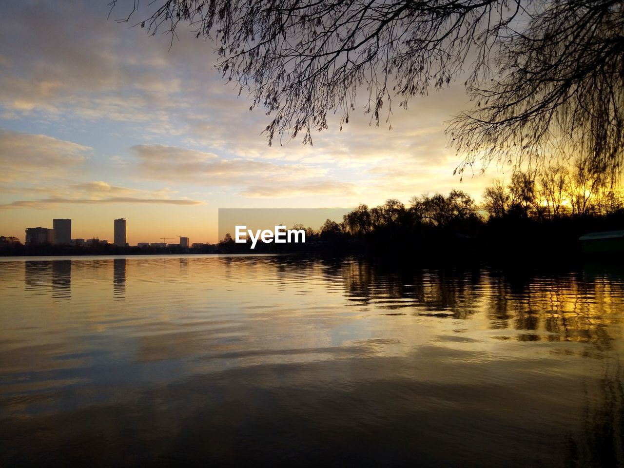 SILHOUETTE TREES BY LAKE AGAINST SKY AT SUNSET