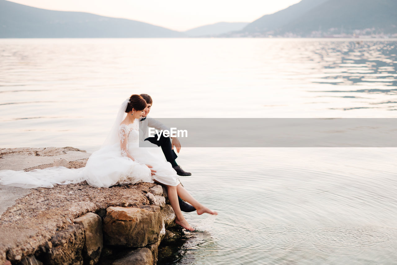 Woman sitting on rock at beach