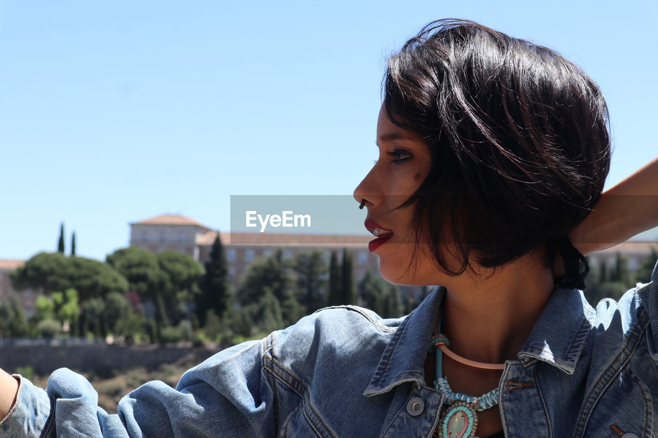 Close-up of woman looking away against sky