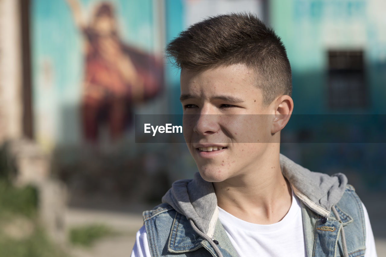 Close-up of boy looking away in sunny day