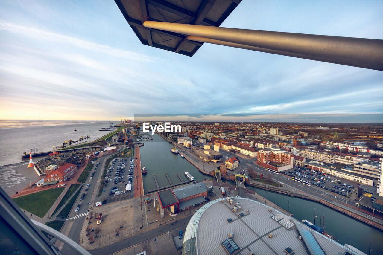 HIGH ANGLE VIEW OF CITYSCAPE AND AIRPLANE ON RUNWAY