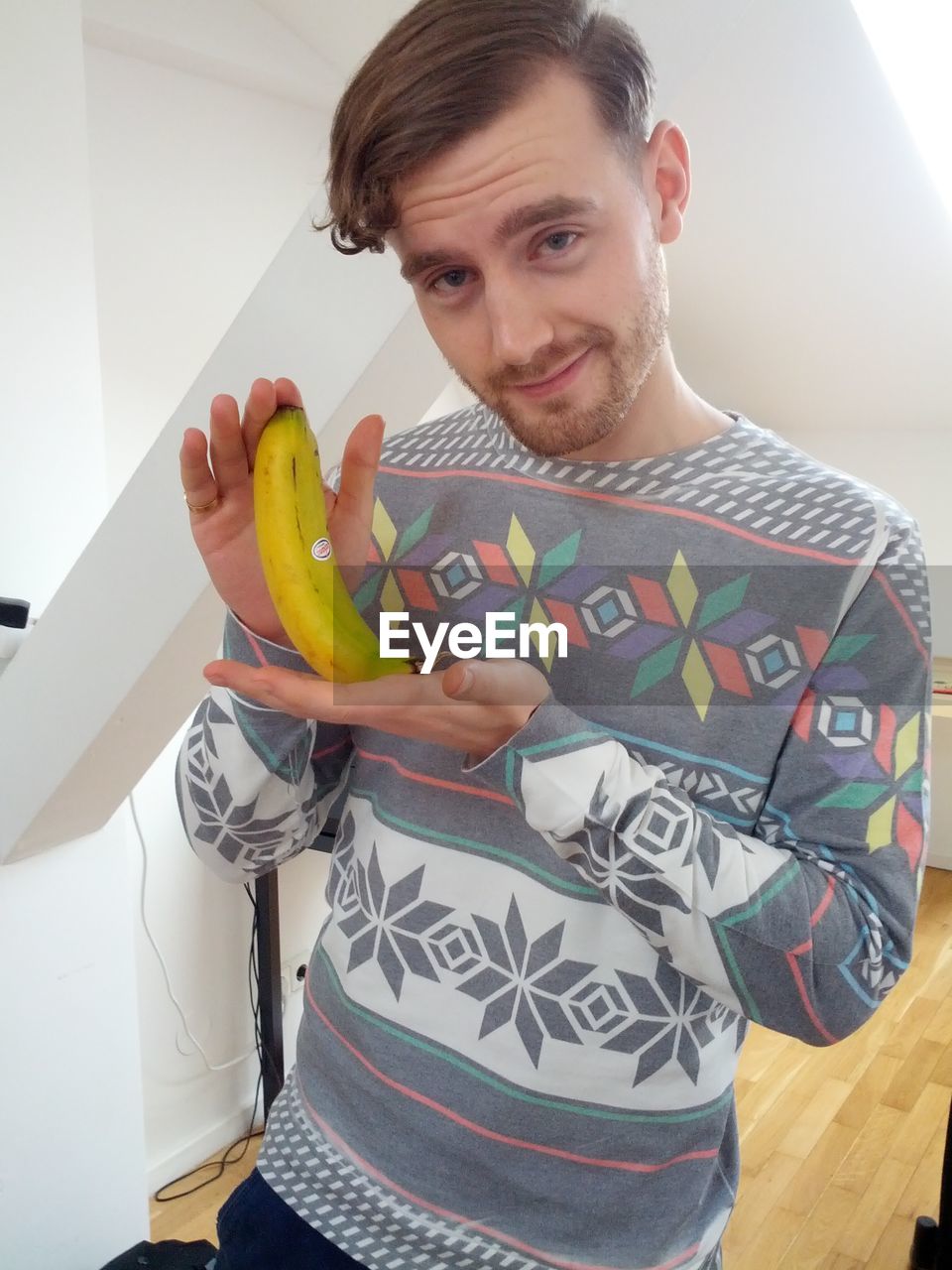 Portrait of man holding banana