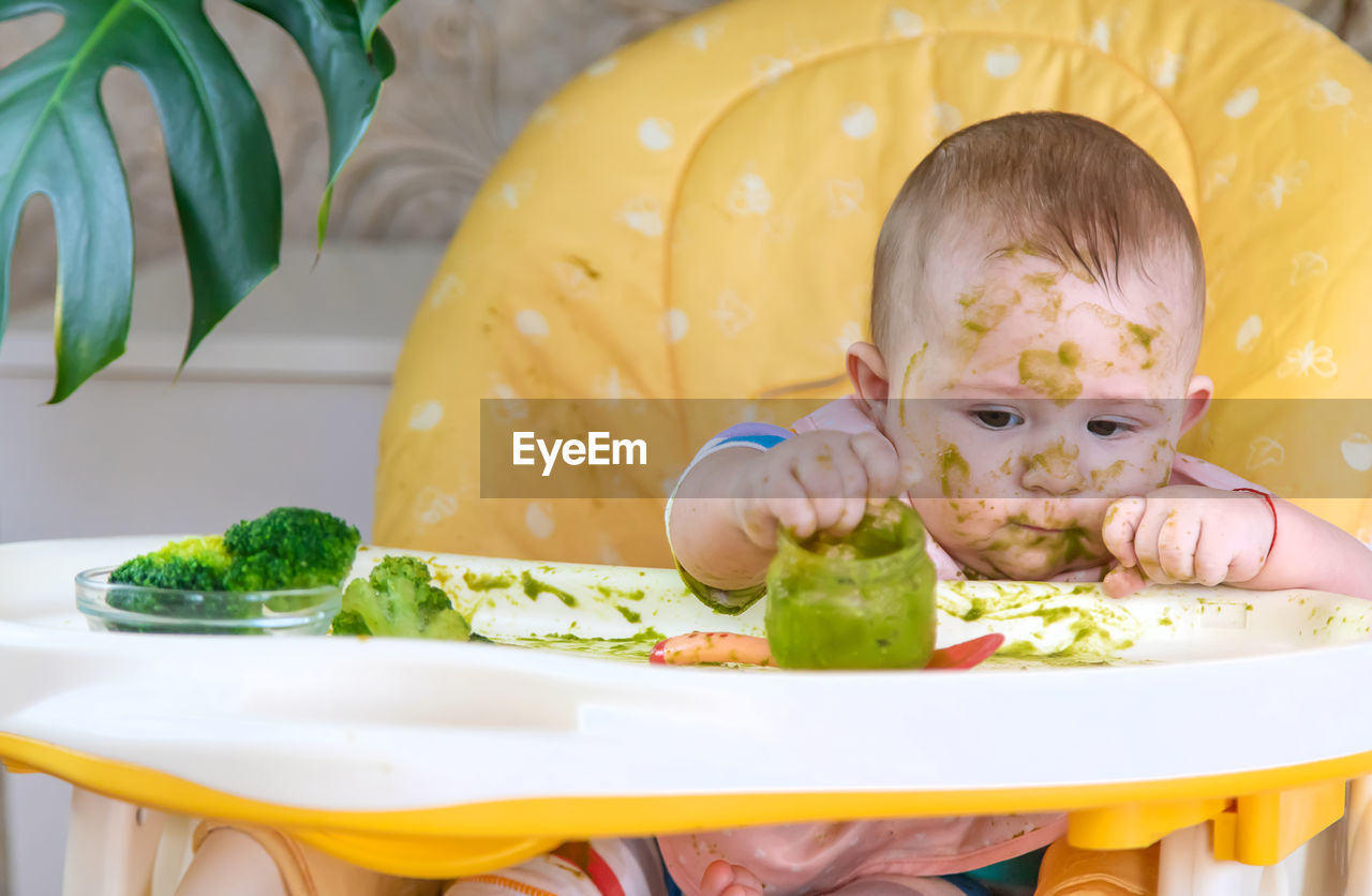 close-up portrait of cute girl eating food on table