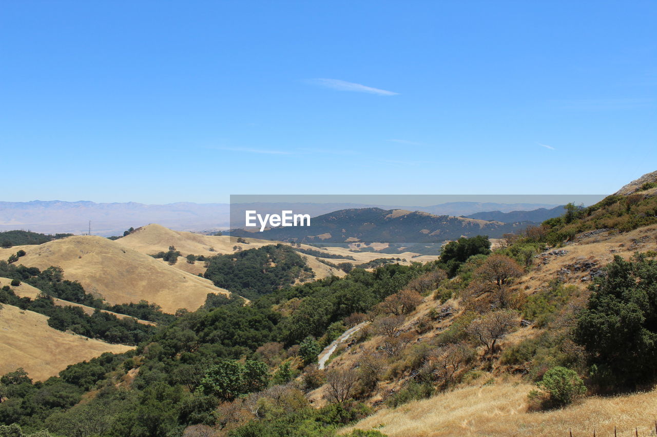 Scenic view of mountains against blue sky