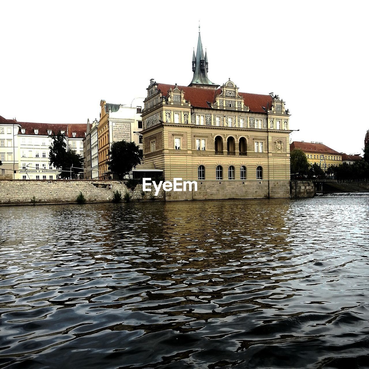 Building by river against clear sky