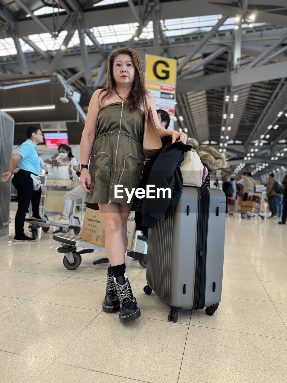 adult, travel, women, indoors, luggage, full length, airport, transportation, suitcase, journey, standing, smiling, female, air vehicle, happiness, young adult, mode of transportation, luggage and bags, portrait, passenger, looking at camera, clothing, trip, fashion, emotion, vacation, holiday, walking, front view, group of people, holding