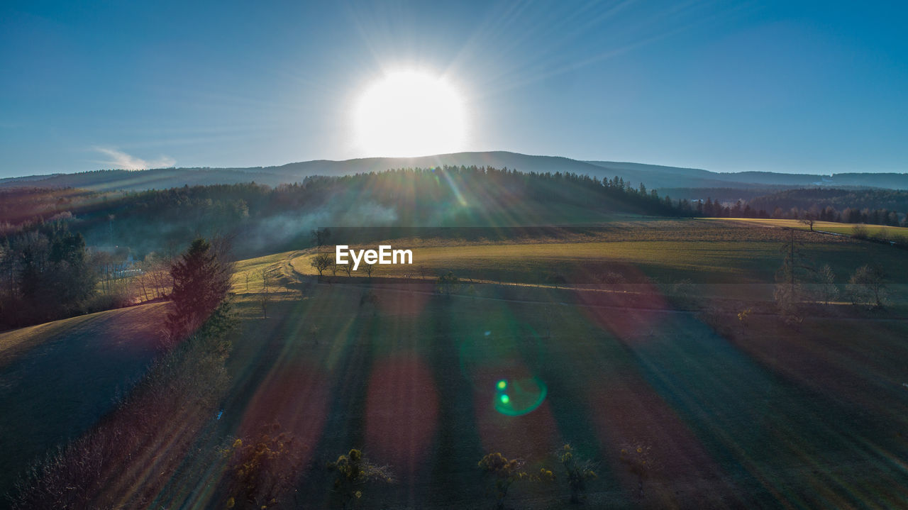 Scenic view of field against sky on sunny day