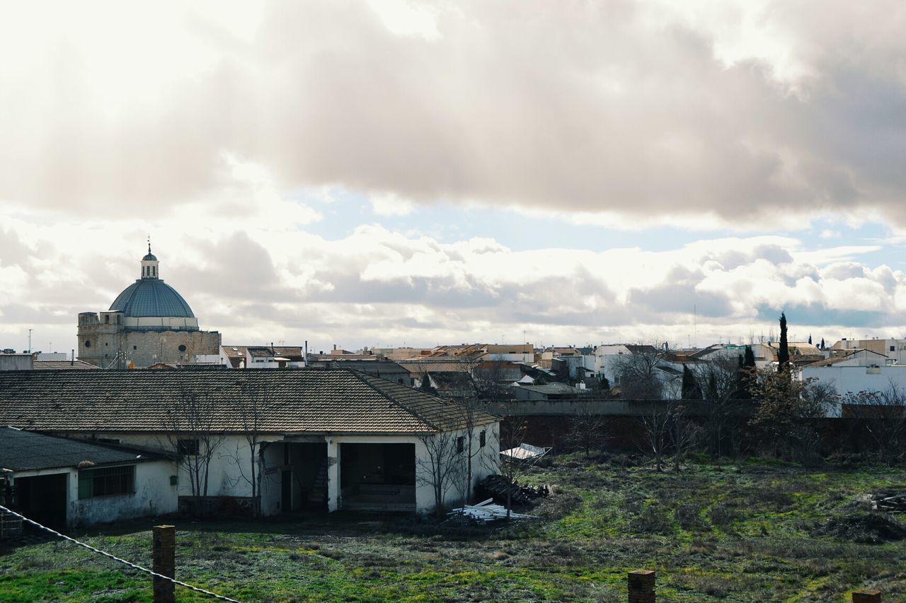 HOUSES AGAINST CLOUDY SKY