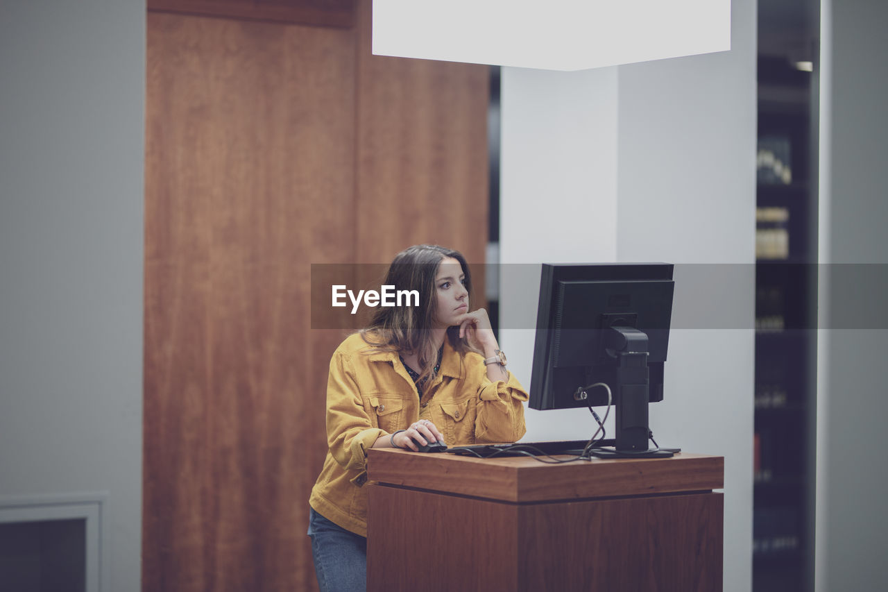 Young woman using computer on table