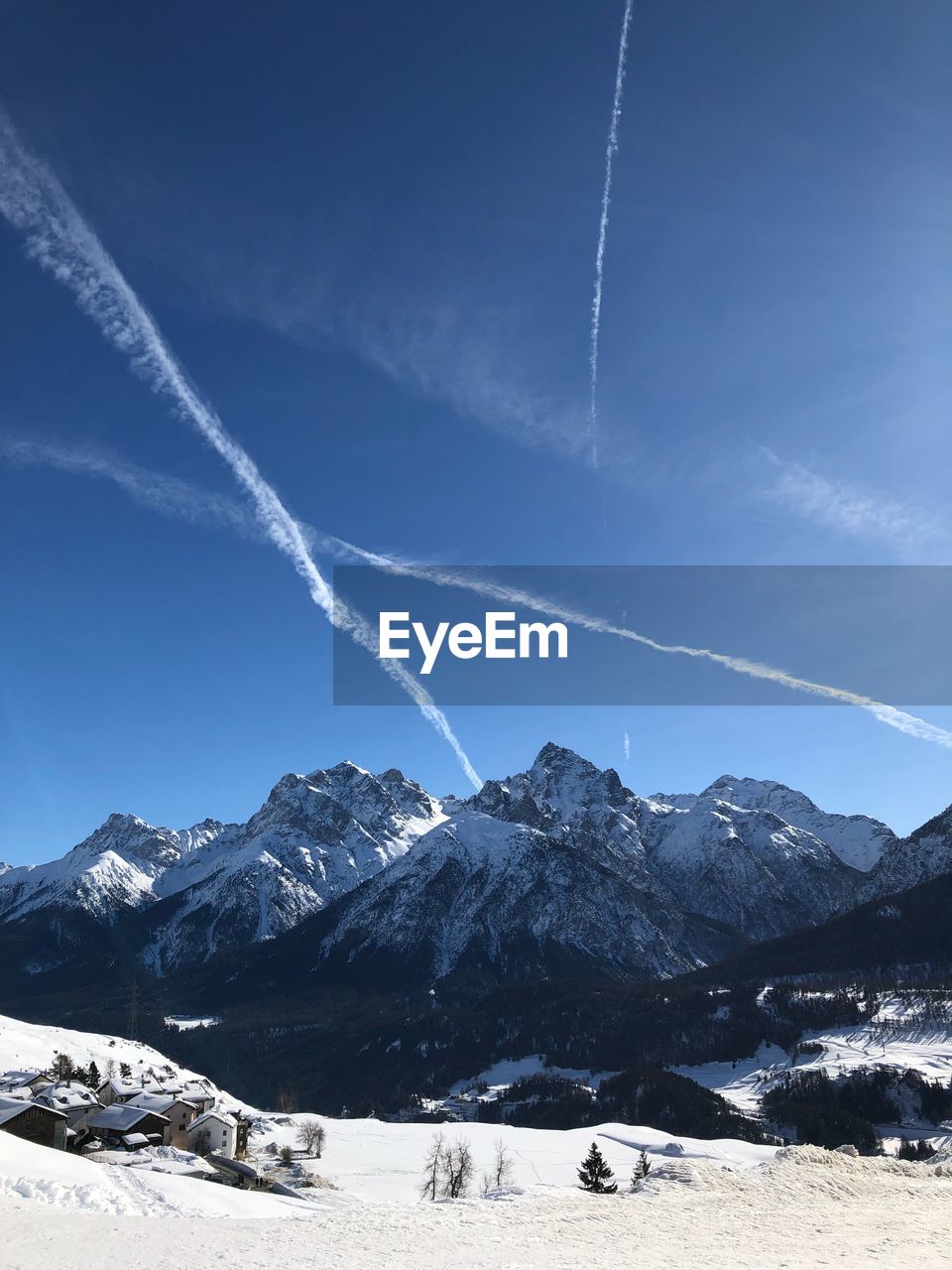 Scenic view of snowcapped mountains against blue sky