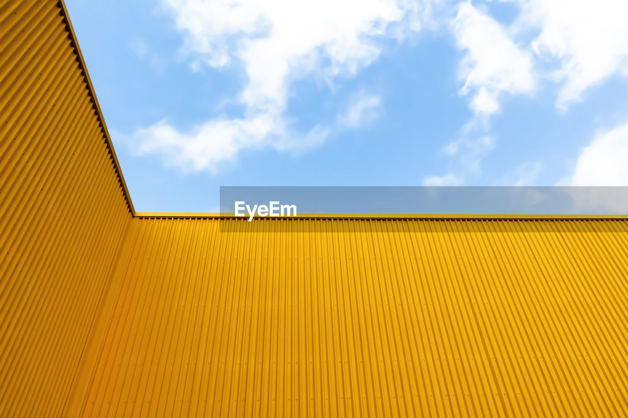 LOW ANGLE VIEW OF YELLOW ROOF OF BUILDING AGAINST SKY