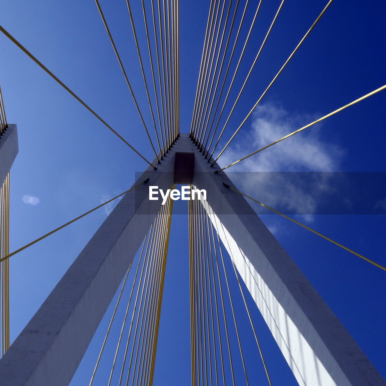 Low angle view of suspension bridge against blue sky