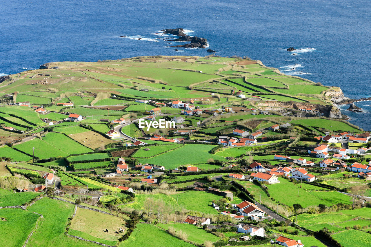 High angle view of houses by sea against sky, portugal, azores, flores
