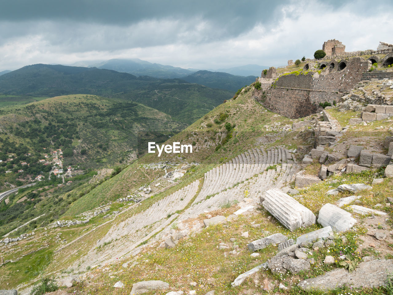 HIGH ANGLE VIEW OF RUINS OF MOUNTAIN AGAINST CLOUDY SKY