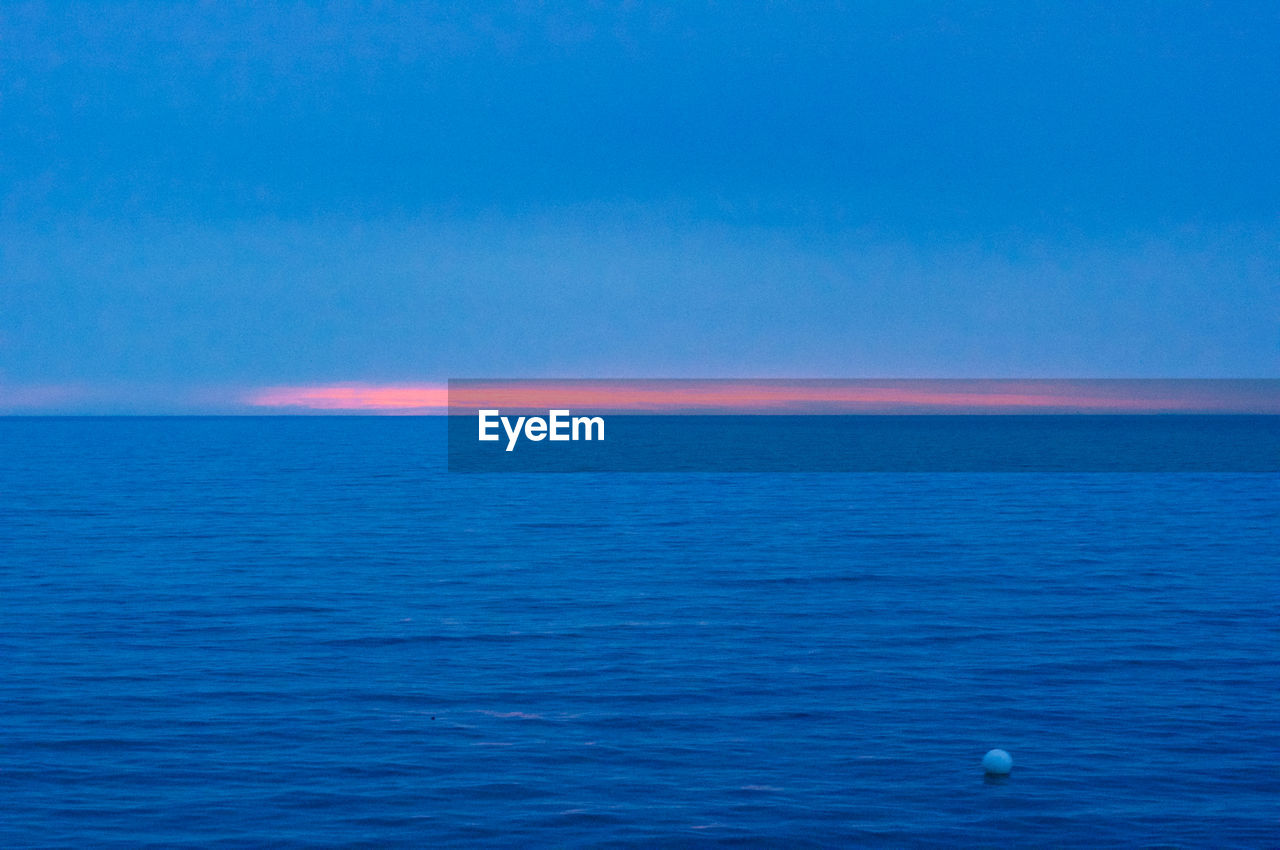 Scenic view of calm sea against blue sky