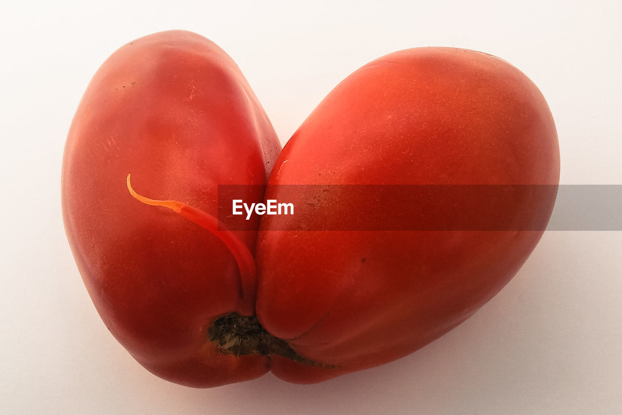 CLOSE-UP OF RED FRUIT ON WHITE BACKGROUND