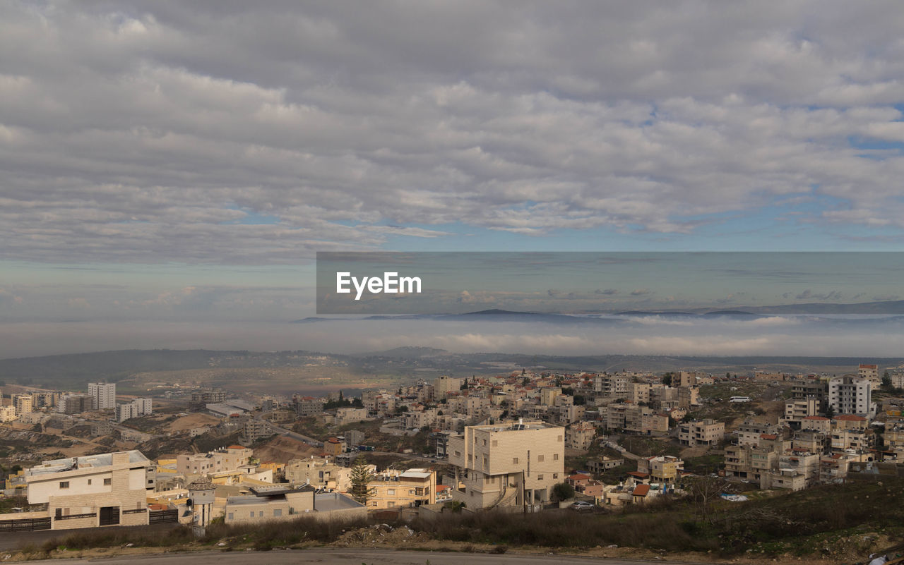 HIGH ANGLE VIEW OF BUILDINGS IN CITY AGAINST SKY