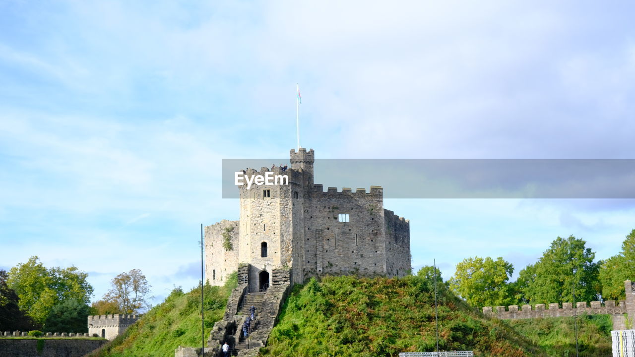 architecture, built structure, history, the past, sky, building exterior, castle, château, building, cloud, tree, fort, nature, plant, travel destinations, tower, travel, fortified wall, medieval, old, day, wall, no people, tourism, outdoors, ancient, land, blue