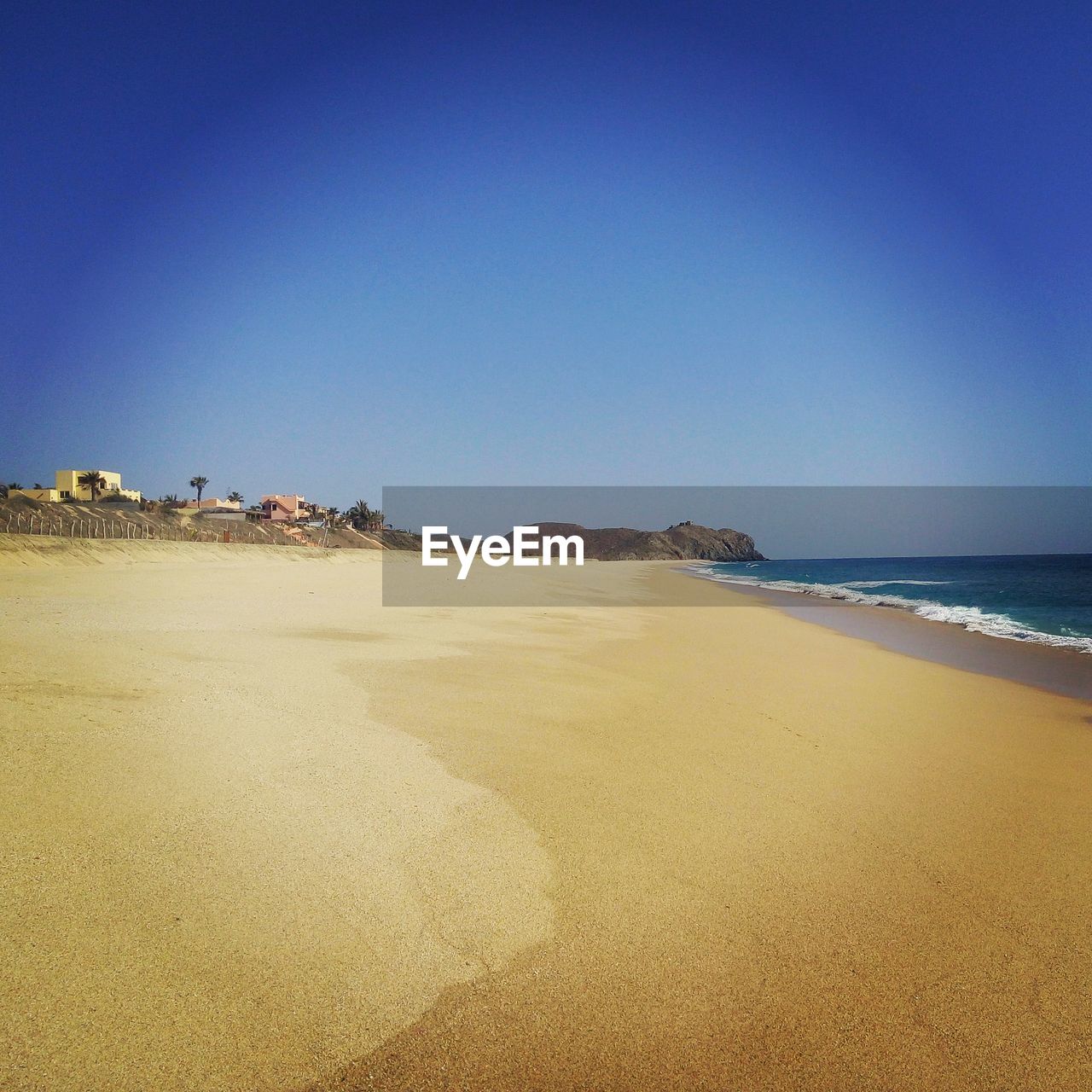 Scenic view of beach against blue sky