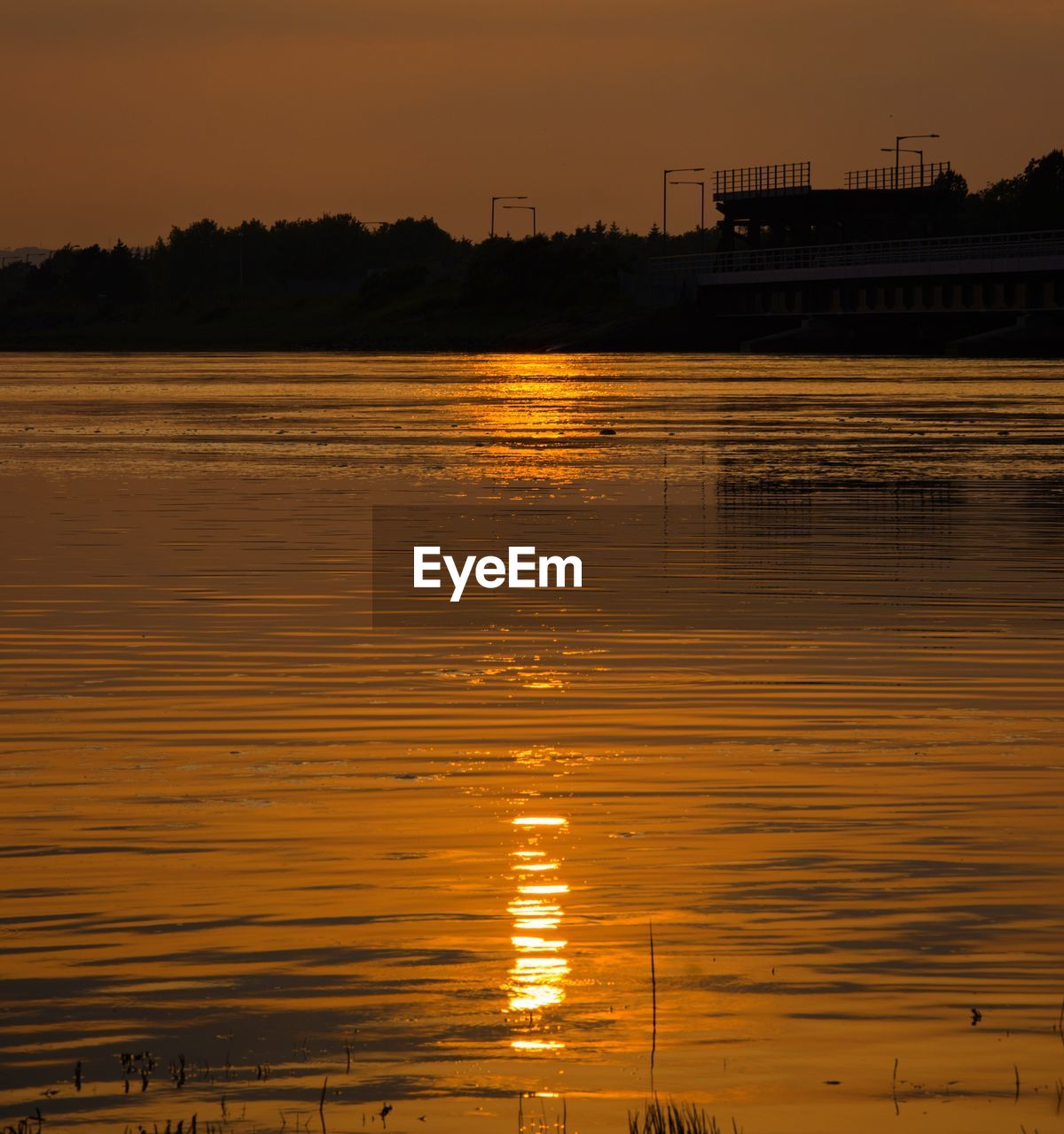 Scenic view of lake against orange sky