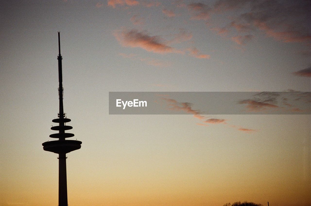 low angle view of street light against cloudy sky during sunset