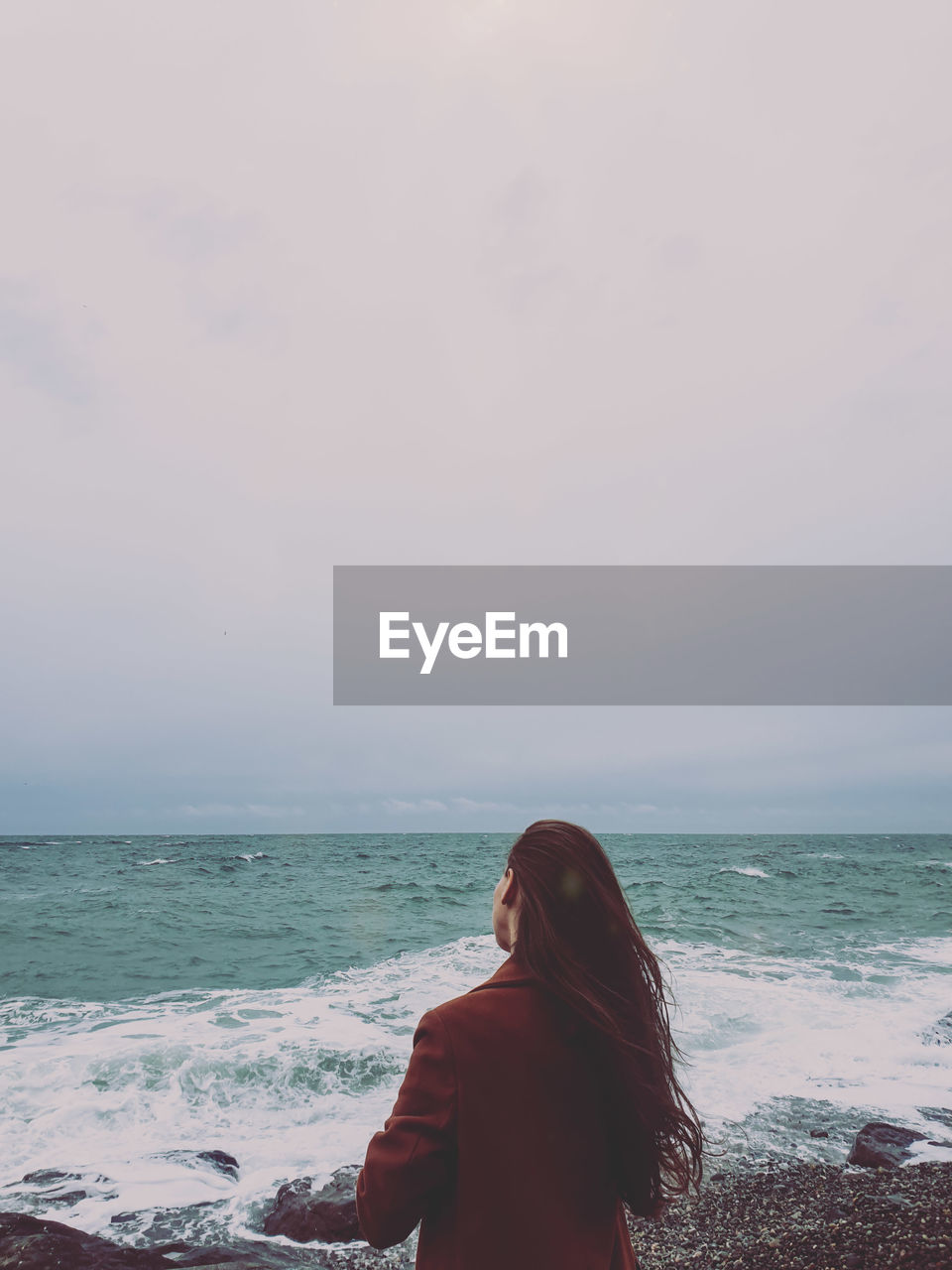 Rear view of woman looking at sea against sky