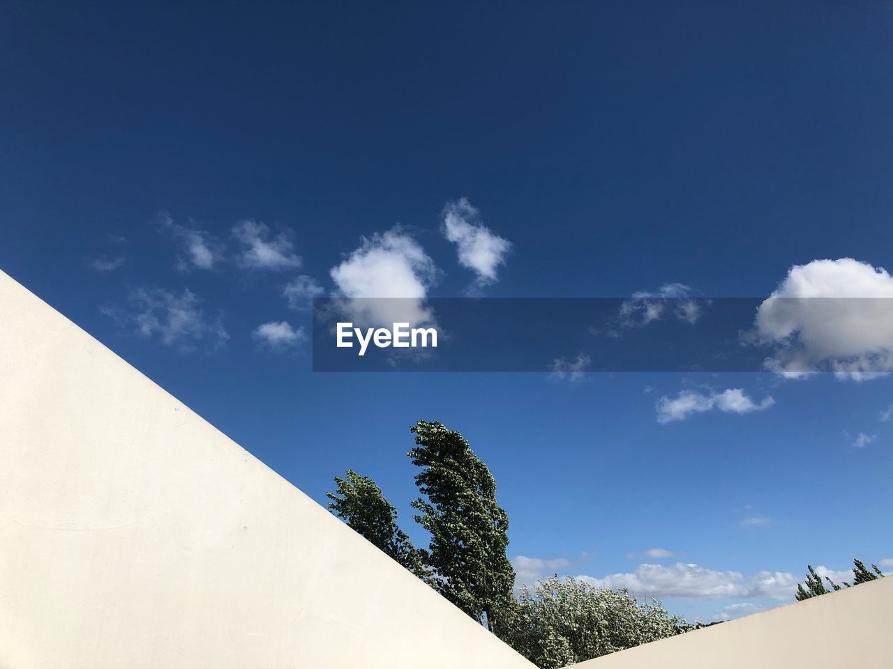 LOW ANGLE VIEW OF BUILDINGS AGAINST BLUE SKY