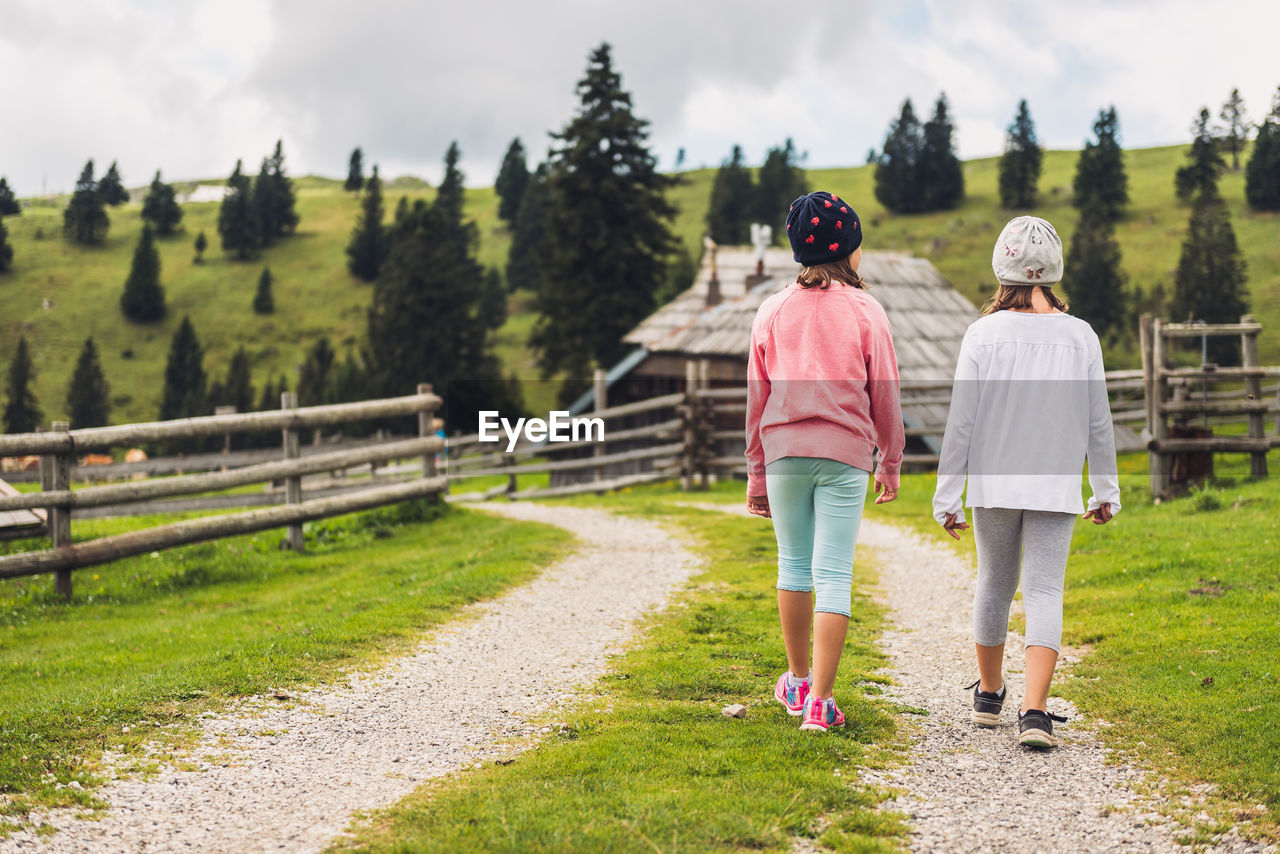 Rear view of women walking on footpath