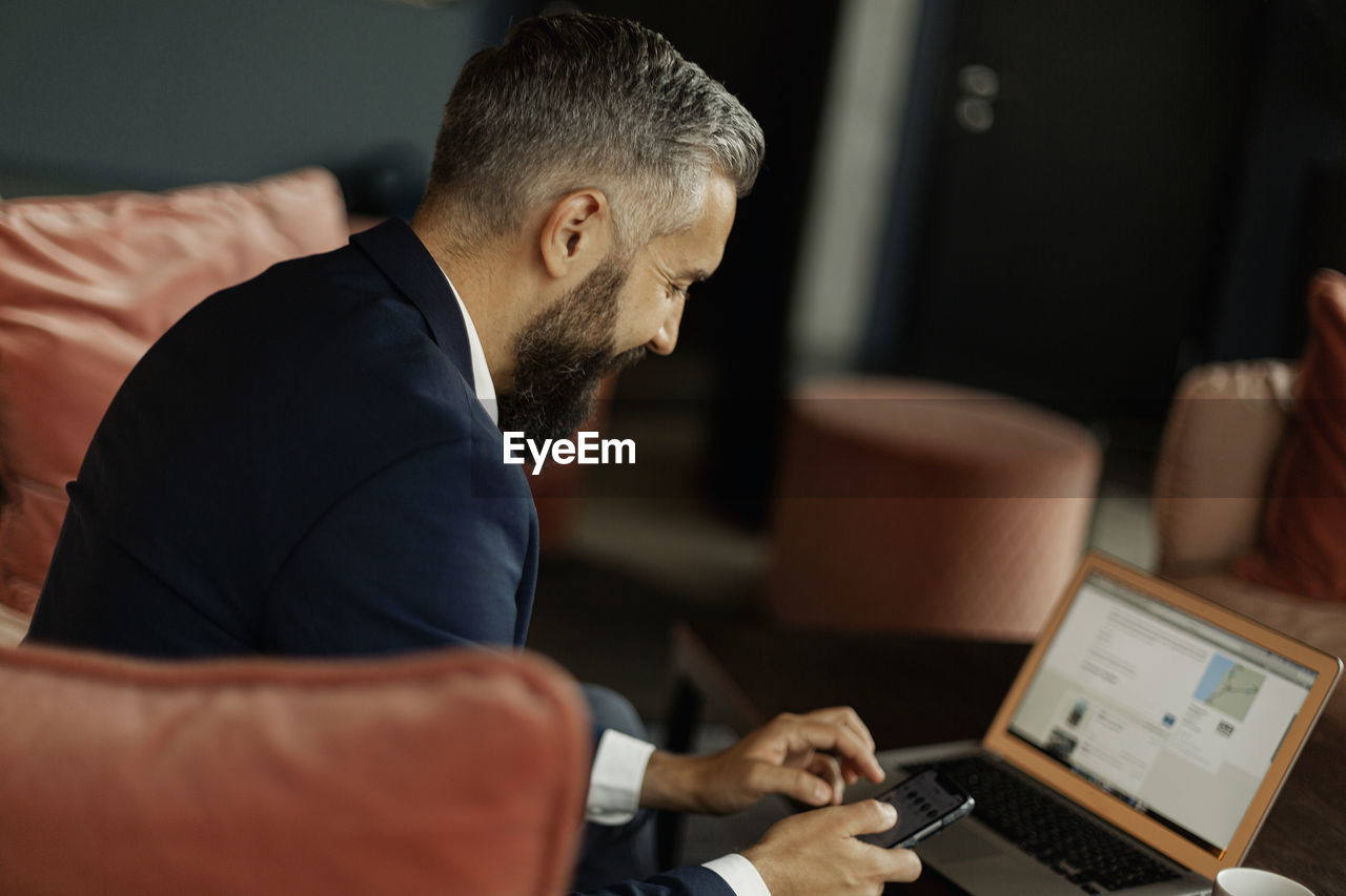 Businessman using cell phone in cafe