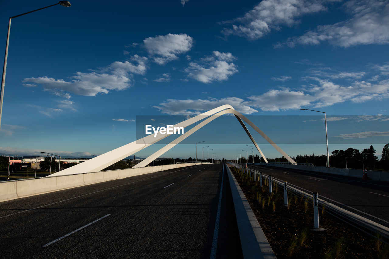 View of bridge in city against blue sky