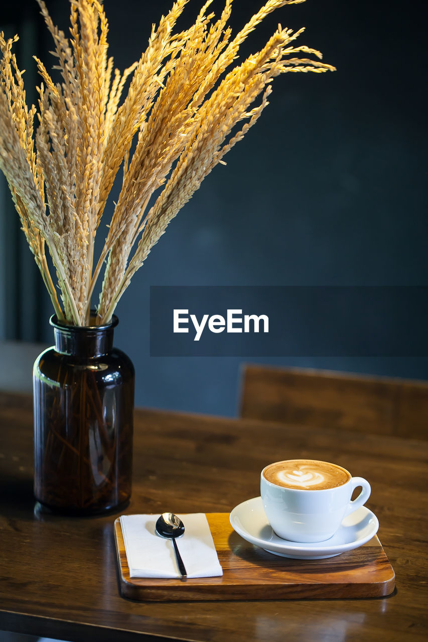 Cup of coffee on wooden table, vintage color