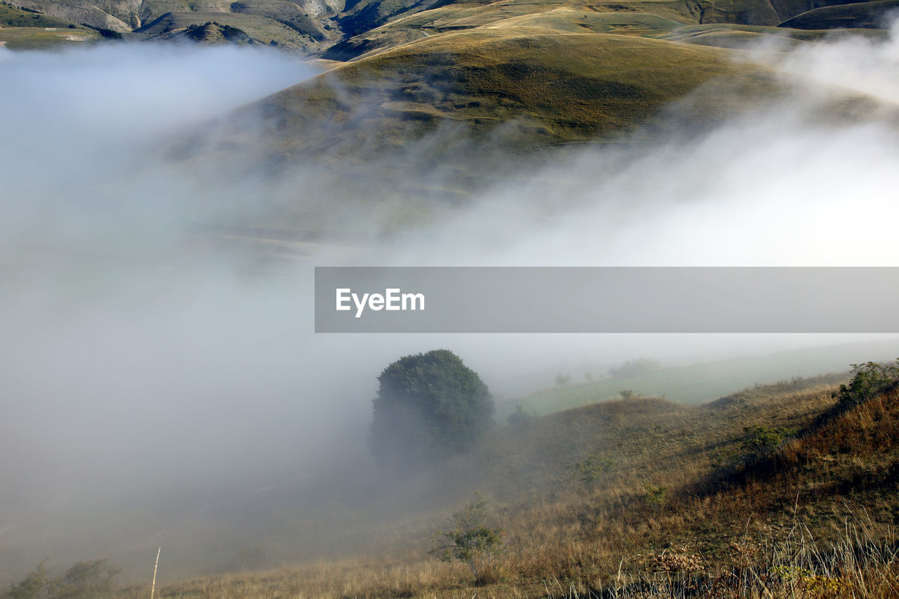 Scenic view of fog over land