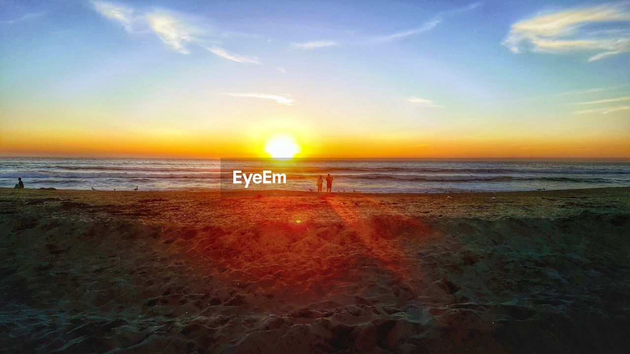 SCENIC VIEW OF BEACH AT SUNSET