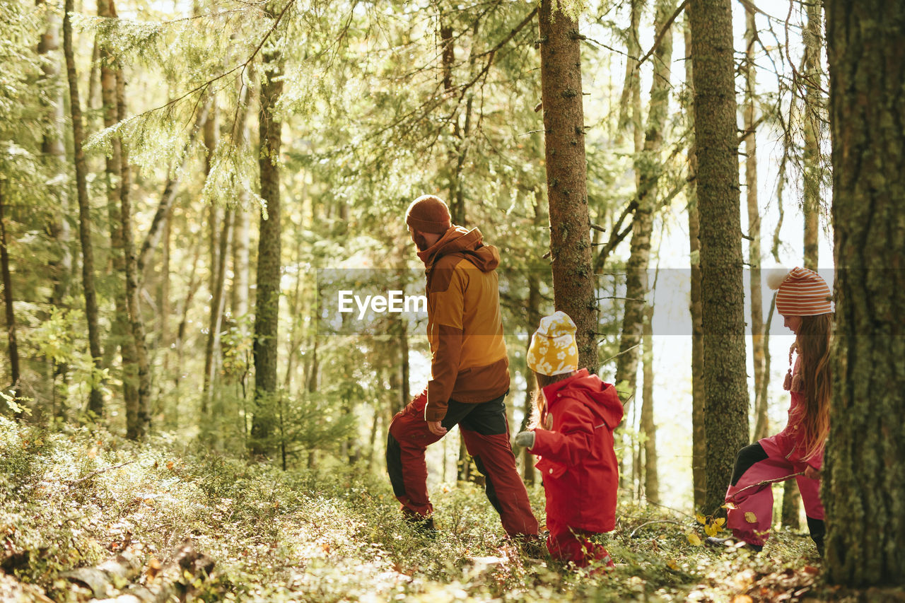 Father with daughter walking through forest