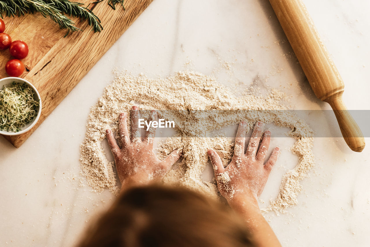 High angle view of child hand preparing food