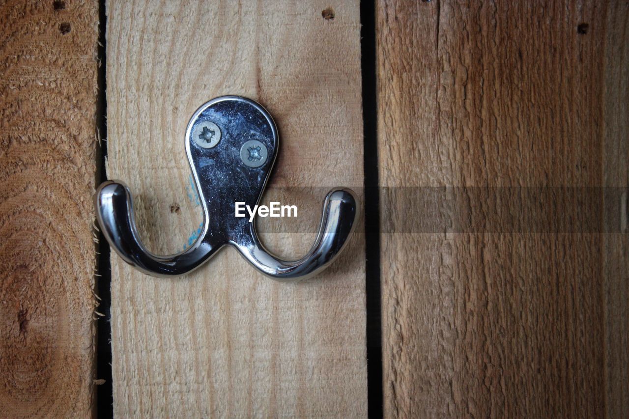 Close-up of hook mounted on wooden wall