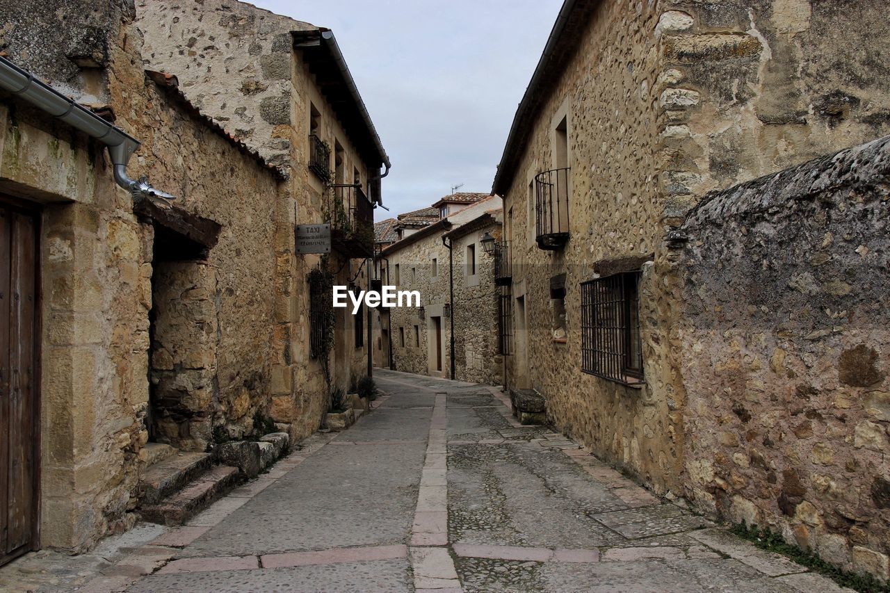 Empty street amidst old houses in town