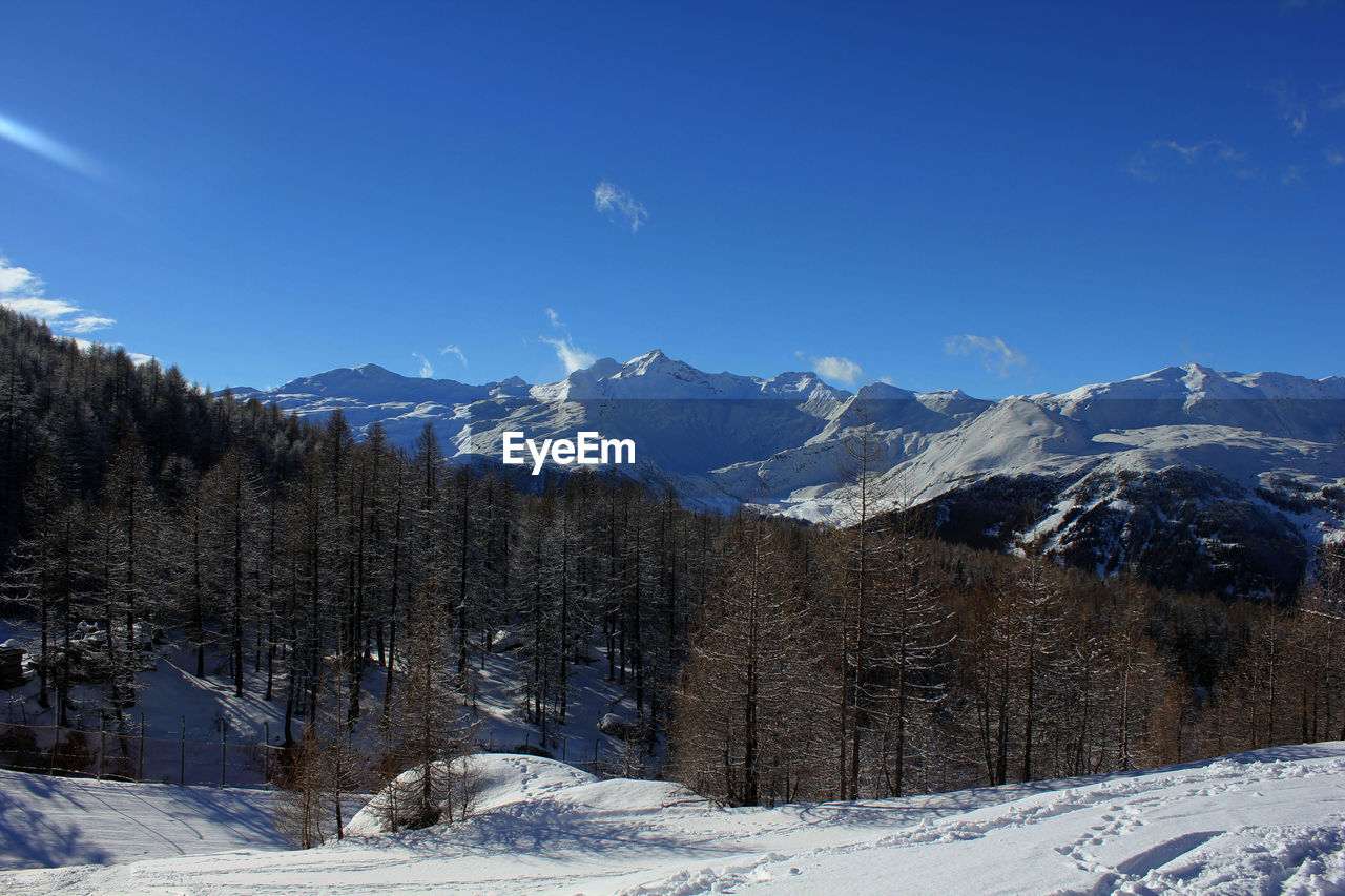 Scenic view of snowcapped mountains against clear blue sky