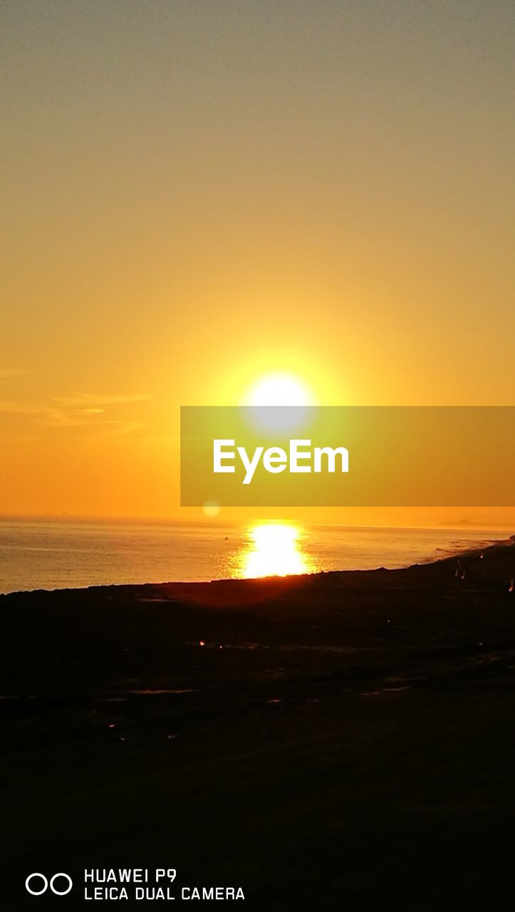 SCENIC VIEW OF SEA AGAINST ORANGE SKY DURING SUNSET