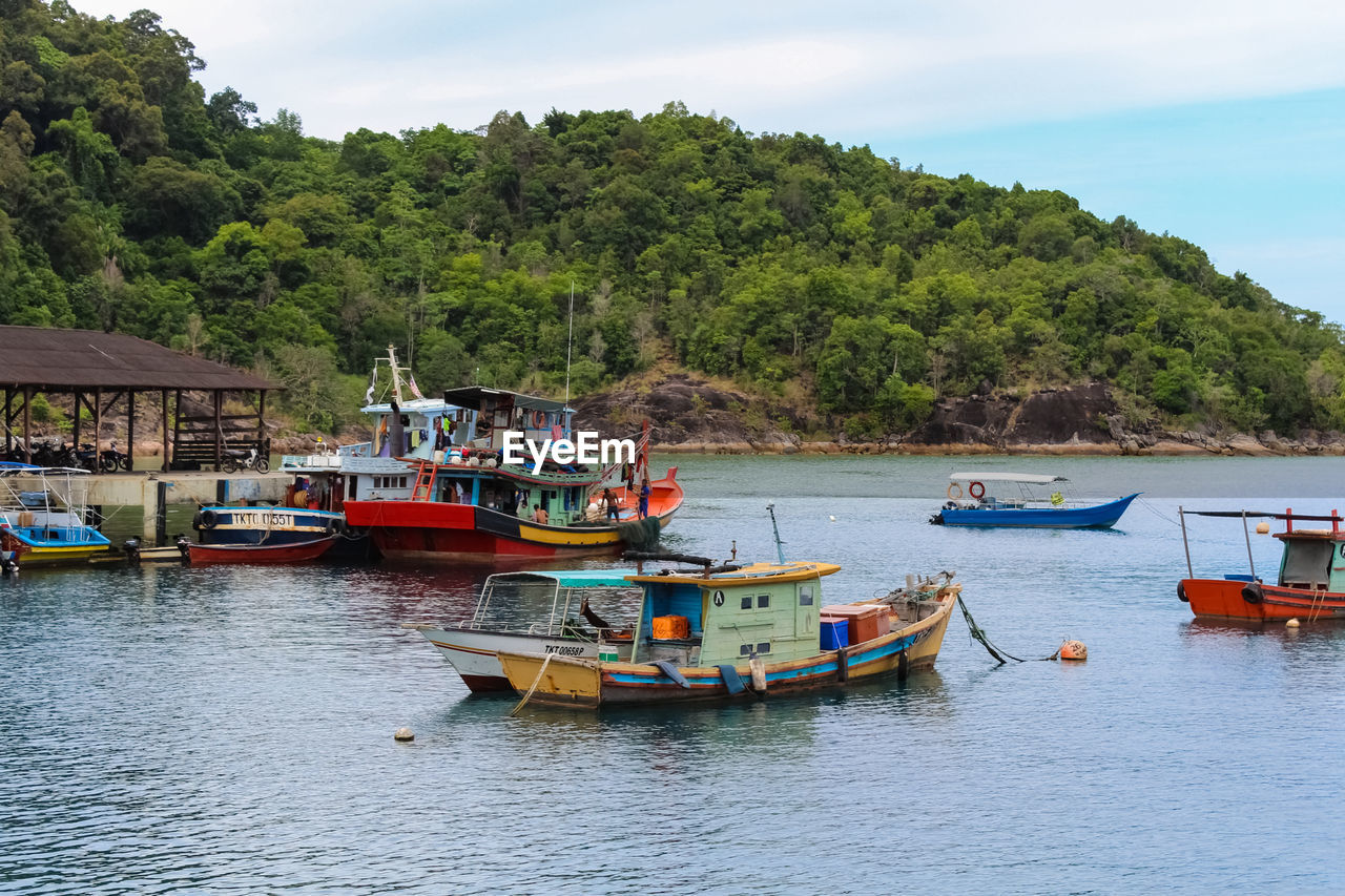 BOATS MOORED ON SEA AGAINST SKY