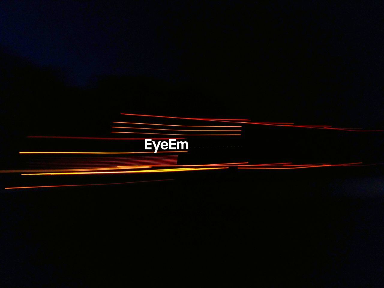 LIGHT TRAILS ON ROAD AT NIGHT