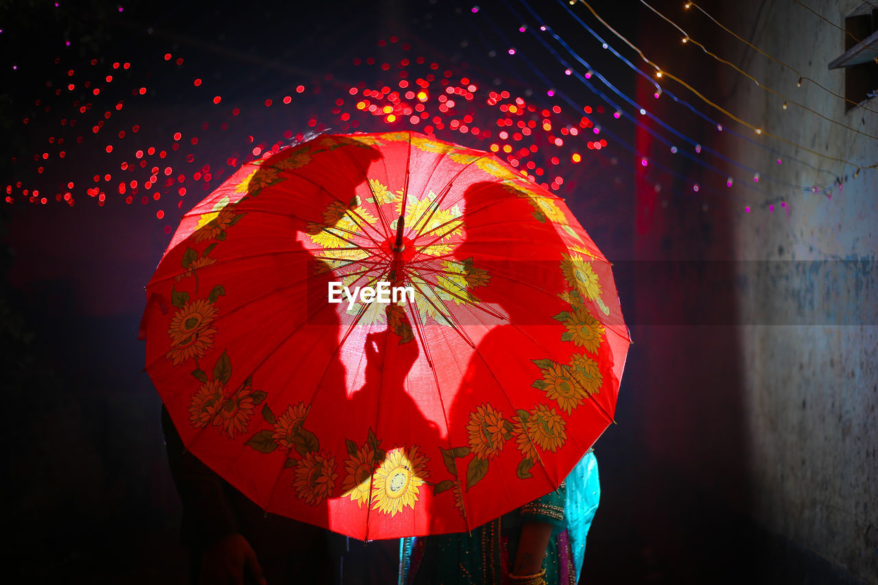 Low angle view of illuminated lanterns hanging at night